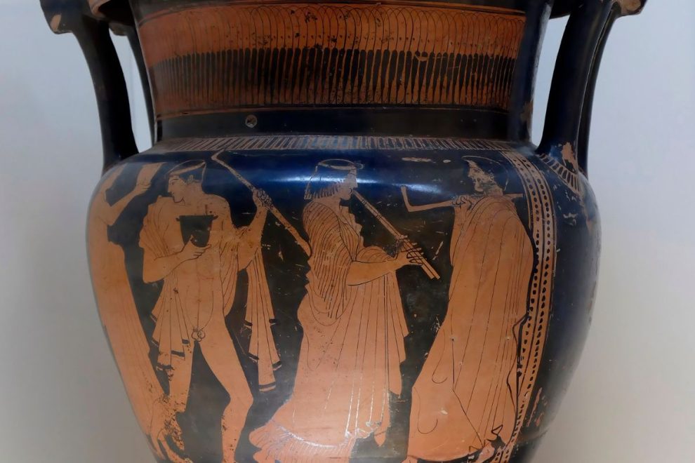 An ancient Greek pottery piece depicting a scene of musicians and dancers, featuring detailed figures playing instruments and adorned with traditional patterns.