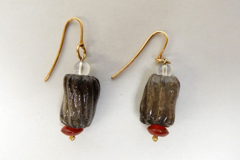 Handmade Ancient Greek-inspired earrings with dark ridged beads, small red accents, and gold hooks.