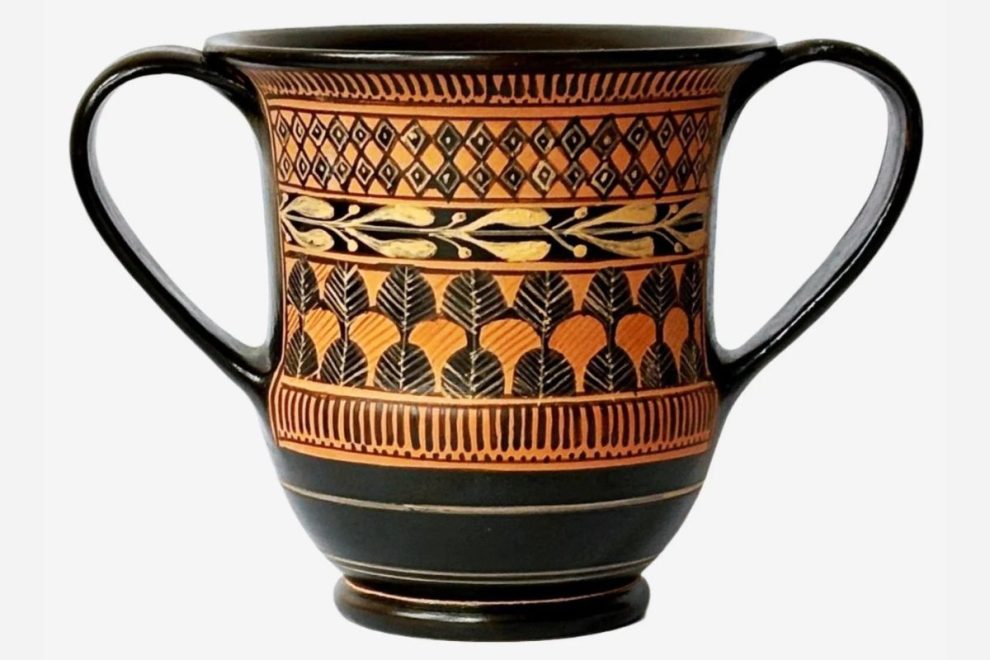 A two-handled black vessel decorated with terracotta-colored patterns in an Ancient Greek style