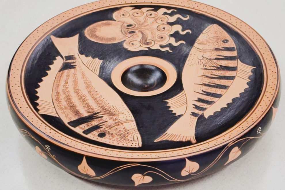 A Boston fish plate, an ancient Greek ceramic dish featuring detailed depictions of fish and a central circular depression.